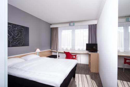 柏林ibis Berlin City Nord的配有一张床和一张书桌的酒店客房