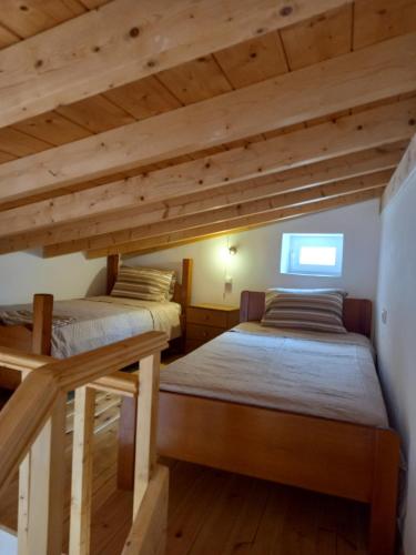 爱琴娜岛APANEMA HOUSE的配有木天花板的客房设有两张床。