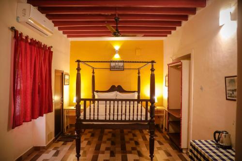 蓬蒂切里The French Villa的红色窗帘的房间的一张床位