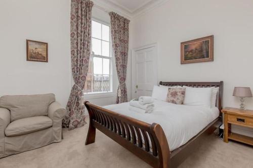 爱丁堡St James Quarter 2 Bed Apartment的一间卧室配有一张床、一张沙发和一个窗口