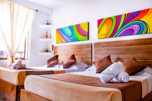 圣罗莎德卡瓦尔Hotel Plaza Real的墙上画作的房间里设有两张床