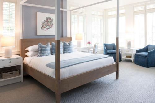 AuroraInns of Aurora Resort & Spa的一间卧室配有天蓬床和蓝椅