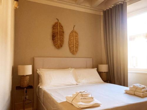 贝加莫Gatto Bianco Bergamo Apartment的一间卧室配有一张床,上面有两条毛巾