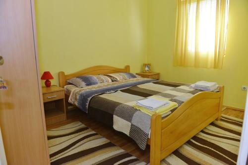 佩鲁恰茨Kuca za odmor Dragina的一间卧室配有带2个床头柜和1扇窗户的床