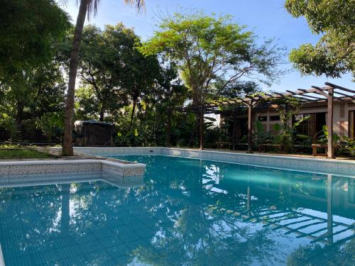 莱昂Hostal Casa Abierta的一座树木繁茂的房屋前的游泳池