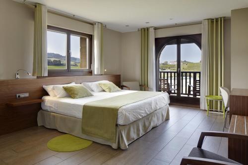 吉塔里亚Hotel Rural Gaintza的一间带大床的卧室和一个阳台