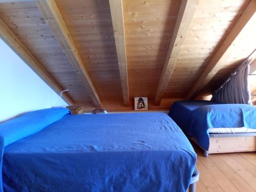 Bugiallocasa vacanze Ca'del Miro Montemezzo的配有木天花板的客房内的两张床