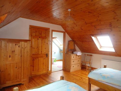 波特马吉Portmagee Seaside Cottages的一间卧室设有一张床和木制天花板