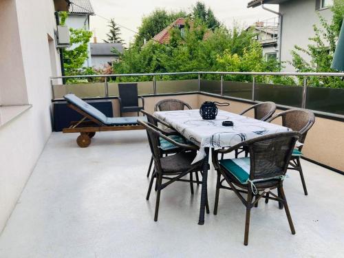 卢布尔雅那Apartment Armic的阳台配有桌椅和桌子