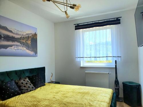 维斯瓦Apartamenty Ski & Fun Spokojna的一间卧室配有一张带黄色床罩的床和窗户