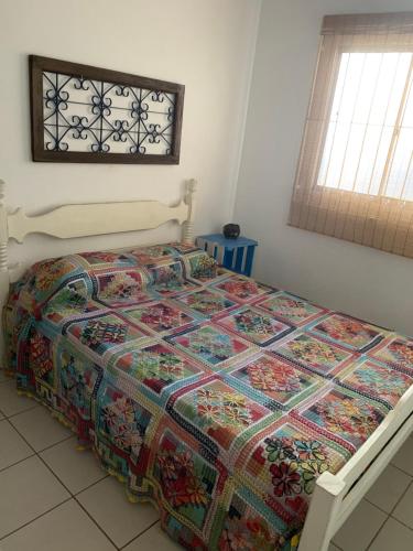 塞拉Casa beira mar Jacaraipe.的卧室里一张床上有五颜六色的被子