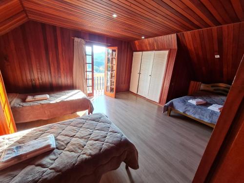坎波斯杜若尔当Casa Vila Telma的一间卧室设有两张床,其中设有窗户。