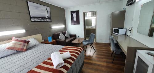 莫韦尔Morwell Parkside Motel的酒店客房配有一张床、一张书桌和一间厨房。