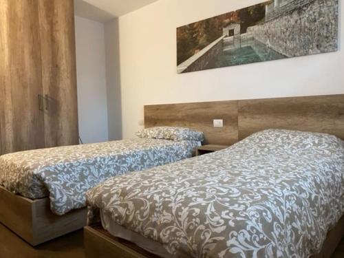 博尔米奥Appartamento trilocale luxory,sulle piste da sci的卧室配有两张床,墙上挂着一幅画