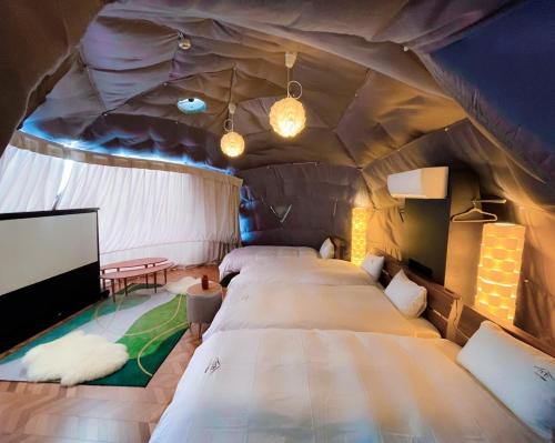 富士河口湖Necoana Glamping的帐篷内带大床的房间
