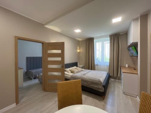 克罗托申Apartamenty Dobranocka的酒店客房带一张床、一张桌子和椅子
