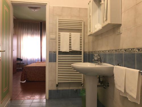 帕多瓦易登酒店的一间带水槽的浴室和一间带床的房间