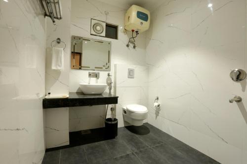 新德里新德里四季机场酒店的白色的浴室设有水槽和卫生间。