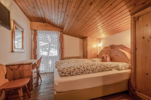 圣维吉利奥Garni Cristallo的一间卧室设有一张床和木制天花板