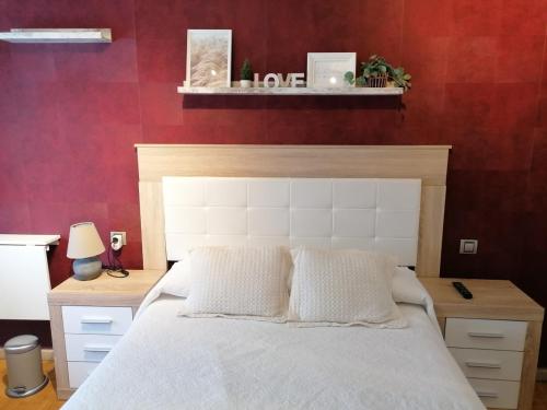 阿斯托加Apartamento Maracaibo的卧室配有白色的床和红色的墙壁