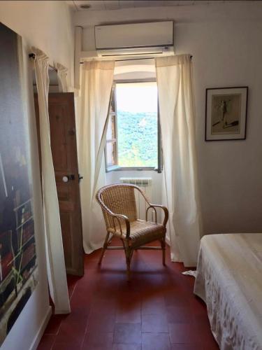 Santa-Reparata-di-BalagnaCasa Divota au cœur d’un village paisible的一间卧室配有椅子和窗户