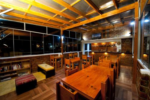 瓦拉斯经典哈卡尔旅馆的餐厅设有木桌、椅子和窗户。