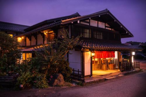 高山阿苏娜若日式旅馆的一间日式房子,前面有一个门