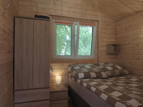 ZdoryDomek mazurski ze świerka syberyjskiego z klimatyzacją的一间小卧室,配有床和窗户