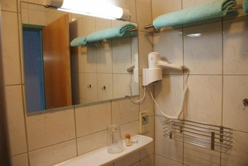KapellnZöchbauer Gästehaus - Hotel Garni的浴室设有镜子和带吹风机的盥洗盆