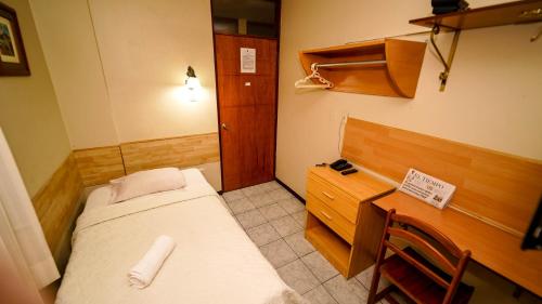 皮乌拉Hotel La Coruña的小房间设有床和木桌