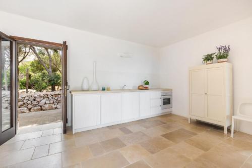 莱乌卡La Dépendance的白色的厨房配有水槽和橱柜