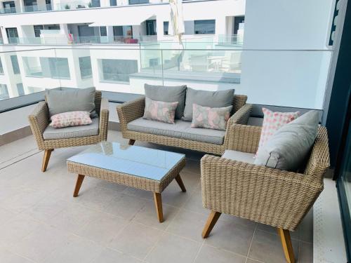 马贝拉Sea view luxury new apartment Marbella Port的阳台的天井配有2把椅子和1张桌子