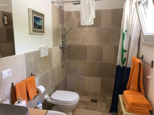 马鲁焦FICOMORO surf house的浴室设有卫生间和带橙色毛巾的淋浴。
