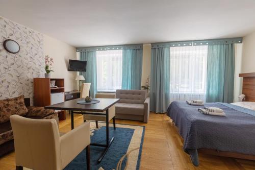 卡尔帕奇萨迪巴SPA酒店的一间卧室配有一张床、一张桌子和一张沙发