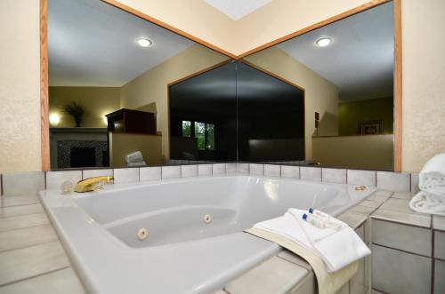 锡达拉皮兹SureStay Hotel by Best Western Cedar Rapids的大型浴室设有大浴缸和大镜子