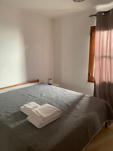 AroeiraAroeira Beach House的一间卧室配有一张带两条白色毛巾的床