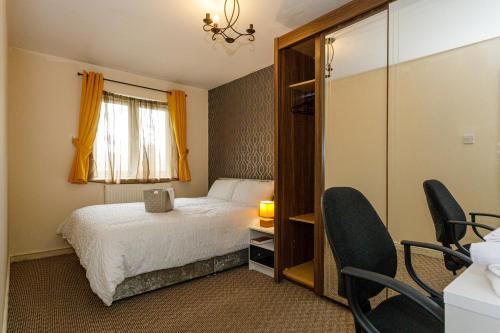 Lees4 beds Sleeps 5- Elegance Leisure Stay, Oldham的一间卧室配有一张床、一个窗口和椅子