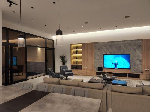 利雅德شاليه فاخر جداً جداً وخاص的带沙发和平面电视的客厅