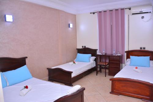 拉希迪耶Hôtel Elfekri的酒店客房配有两张床和一张书桌