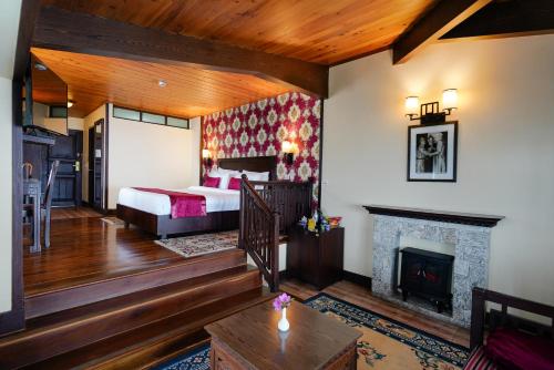 甘托克Denzong Regency- Luxury Mountain Retreat Spa & Casino的一间卧室配有一张床和一个壁炉