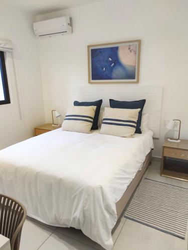 特鲁欧克比赫斯Appartement neuf à Trou aux Biches的卧室配有带蓝色枕头的大型白色床