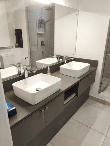 特鲁欧克比赫斯Appartement neuf à Trou aux Biches的一间带两个盥洗盆和大镜子的浴室