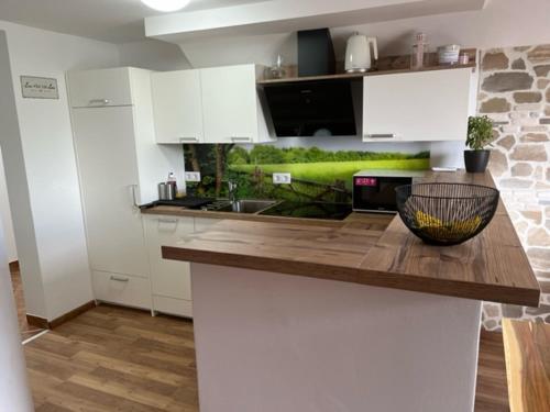 佐尔尼耶戈迪Apartma ELA的厨房配有白色橱柜和木制台面