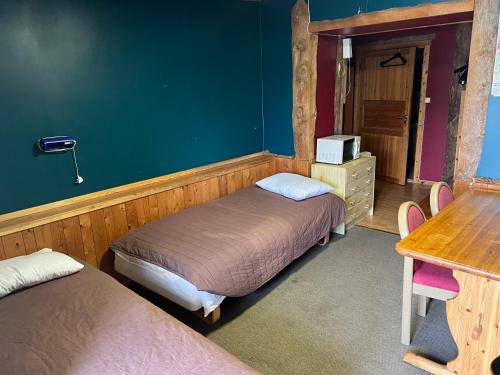 Repvåg莱普韦格酒店的一间卧室配有两张床、一张桌子和一张书桌