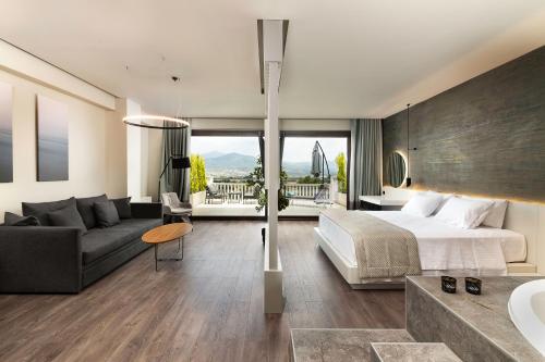 Néon RýsionHeaven Hotel Thessaloniki Airport的一间卧室配有一张床,客厅配有沙发