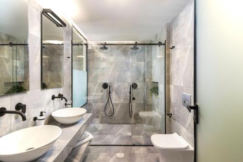 Néon RýsionHeaven Hotel Thessaloniki Airport的一间带两个盥洗盆和淋浴的浴室