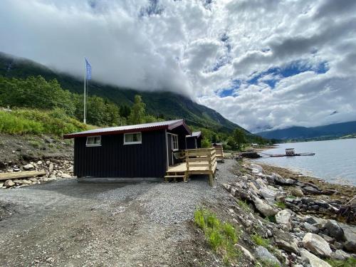 TresfjordFagervik Camping的湖岸上的一个小棚屋