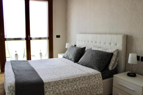 佩罗Rho Fiera Milano - Popy House的卧室配有带灰色枕头的大型白色床