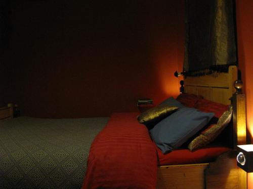 海牙树顶公寓的一间卧室配有一张带红色床单和枕头的床。