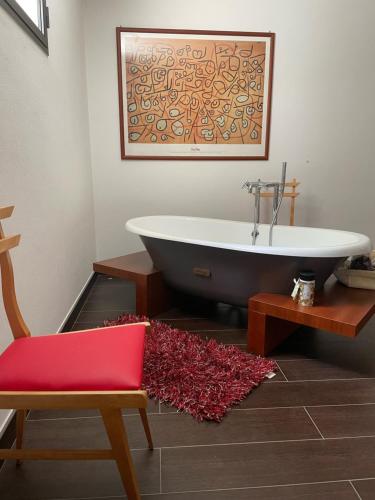 蒙特普齐亚诺La casa dei caprioli appartamento in casale的带浴缸、椅子和地毯的浴室